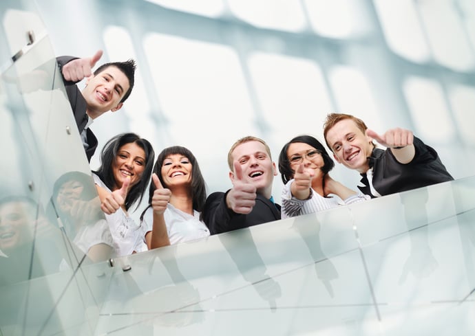 Group of people inside the modern building with thumbs up