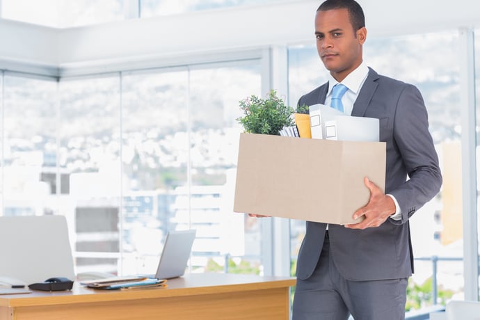 Sad businessman leaving his company while he is holding a box