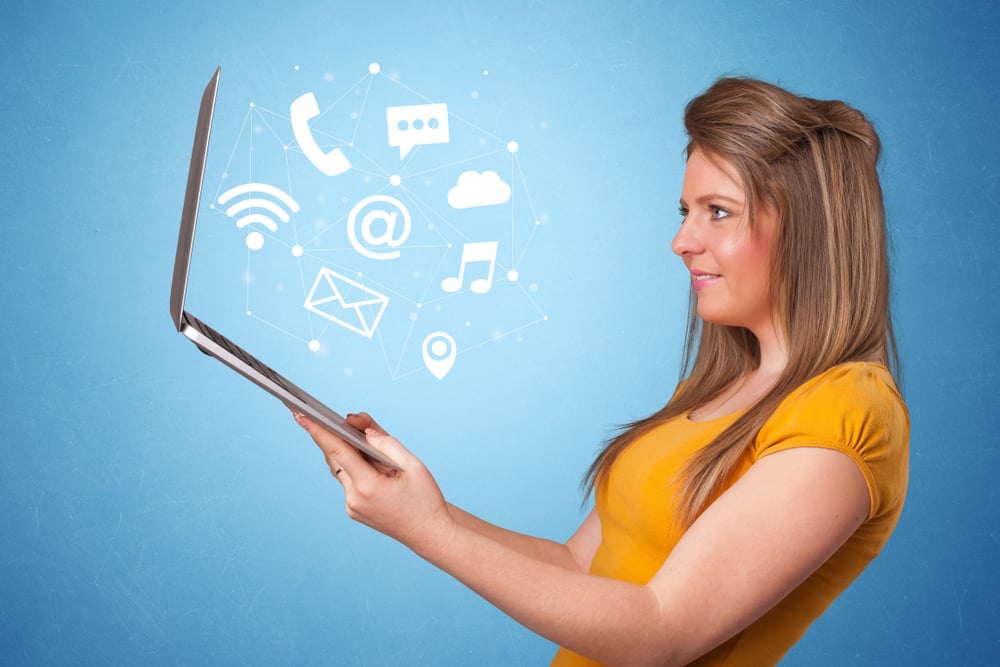 Woman holding laptop with online services symbols